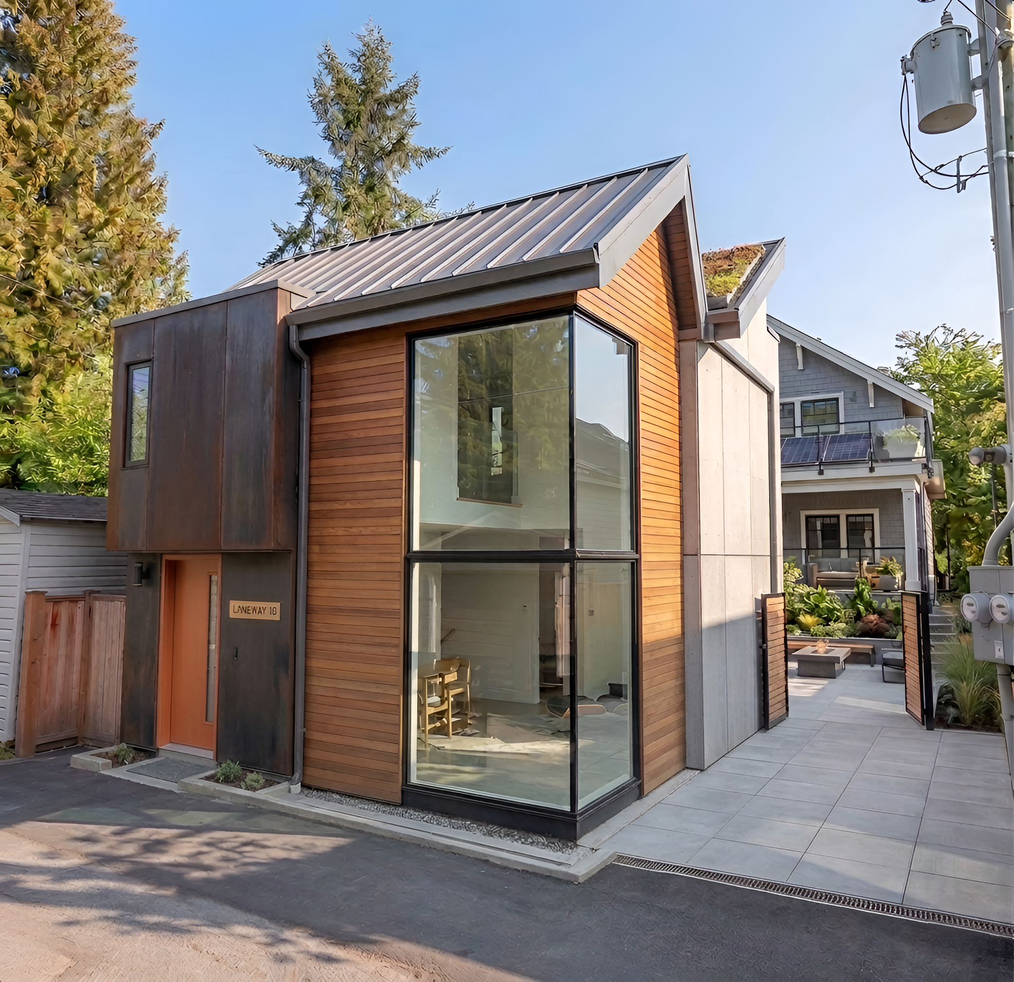 Single-storey cedar and grey laneway home with French doors opening to private patio